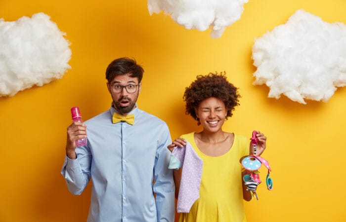 Nastávajúci rodičia s úsmevom a prekvapením držia detské predmety, čo symbolizuje prípravu na nové výzvy. Podobne ako pri práci s Google reklamou, aj podnikatelia potrebujú správne nástroje a stratégiu, aby uspeli.